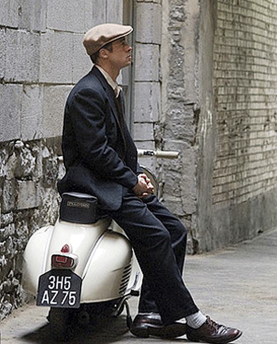  Image of Brad Pitt leaning on a Vespa.